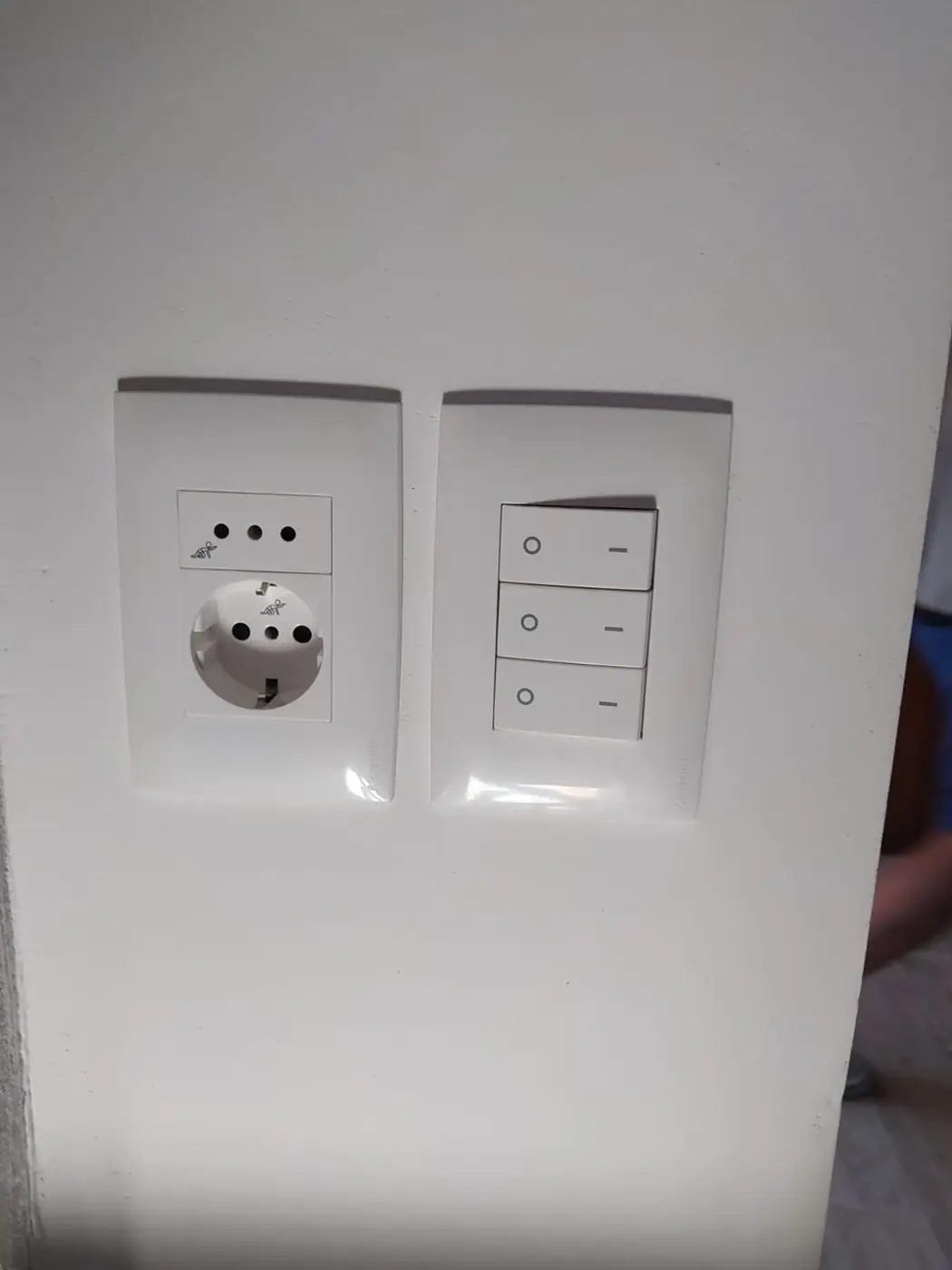 Tomacorriente y llaves de luz instalados en una pared